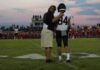 College Football Star Dies After Scoring Touchdown football coach with arm around player number 84 on sideline