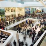Crowded shopping mall interior with multiple levels
