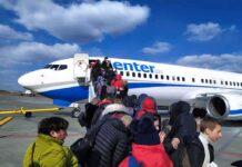 Passengers boarding a commercial airplane via mobile stairs