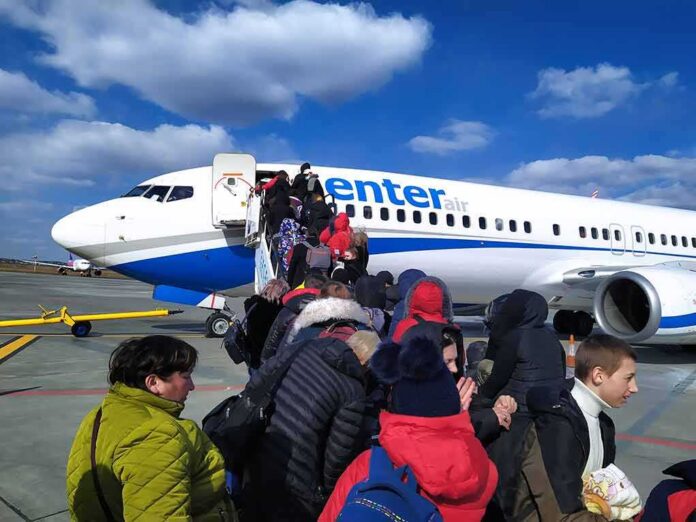 Passengers boarding a commercial airplane via mobile stairs