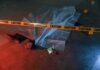 crime scene body under sheet behind caution tape