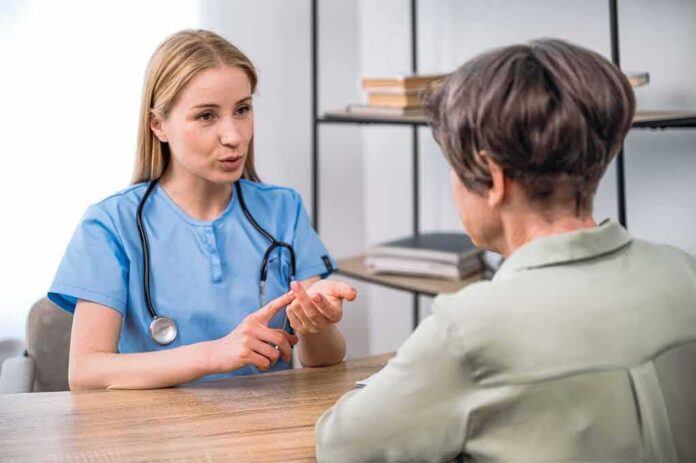 Healthcare professional consulting with an older woman at a desk