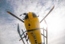 News Chopper CRASHES Mid-Report Yellow helicopter seen from below with spinning rotor against a bright sky