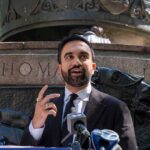 Zohran Mamdani speaking at an outdoor press conference