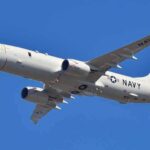 US Navy patrol aircraft flying against a clear blue sky
