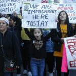Nawal El Saadawi among protesters holding immigration rights signs at a march