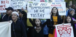 Nawal El Saadawi among protesters holding immigration rights signs at a march
