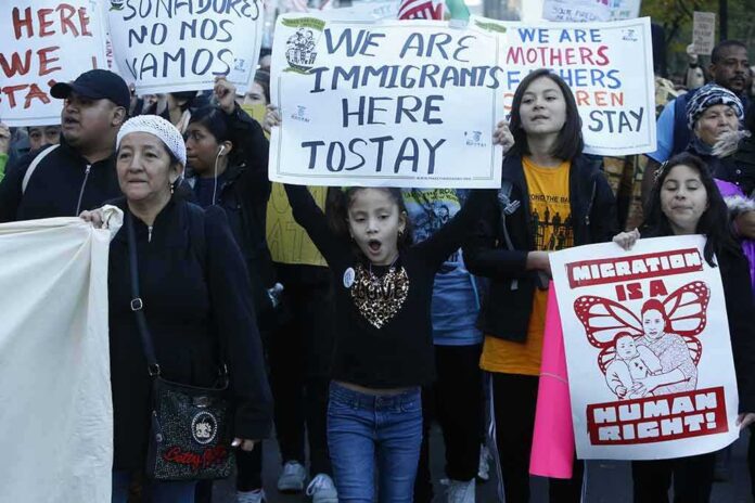 Nawal El Saadawi among protesters holding immigration rights signs at a march