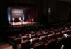 Audience in a theater watching a stage presentation