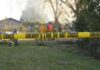 Manic Mom Stabs Her Two Kids Over 50 Times Yellow police tape marking a restricted area at a fire scene with firefighters in the background