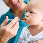 Surrogate SUED For Refusing to Abort Child Baby taking liquid medicine from an oral syringe held by an adult