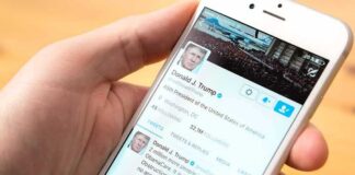 hand holding smartphone showing a social media profile