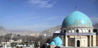 Blue-domed mosque with mountains in the background