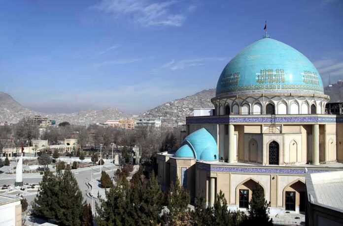 Blue-domed mosque with mountains in the background