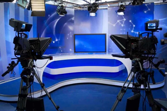 shutterstock_94783030-1 A television studio setup with cameras and a blue backdrop