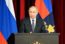 SECOND Person Dies in Russia Plague Outbreak Vladimir Putin speaking at a podium with microphones
