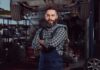 Seven Million Men Vanish From U.S Work Force – WHY? Auto mechanic standing with arms crossed in a garage