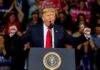 Rap Icon Joins Trump On-Stage During Michigan Rally Donald Trump speaking at a rally podium with arms raised