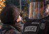 ICE Gunfire Throws NYC Into Carnage protester faces police officer in riot gear