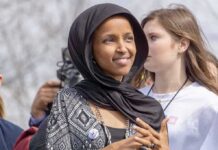Ilhan Omar wearing a black headscarf at an outdoor event