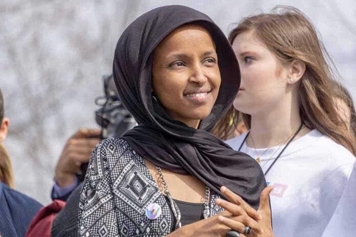 Ilhan Omar wearing a black headscarf at an outdoor event