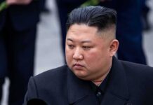 Kim Jong-Un looking to the side in a dark overcoat