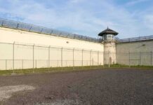 Prison yard with chain-link fence and guard tower