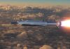 Hypersonic missile flying above clouds with bright exhaust flame